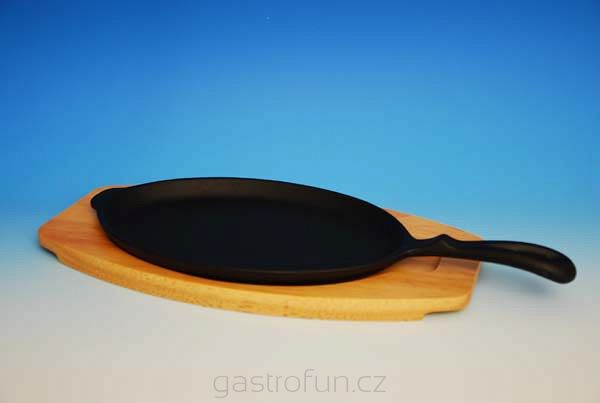 Żeliwna patelnia z drewnianą deską do serwowania fajity.